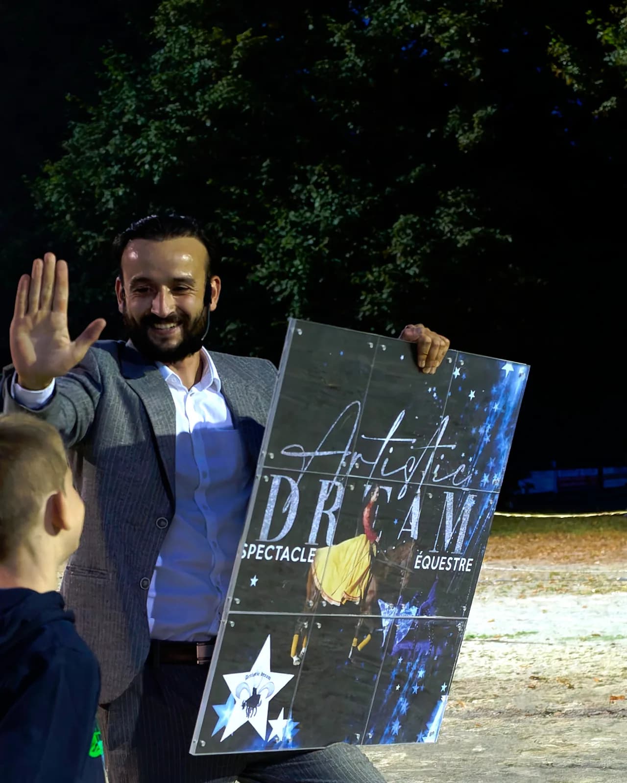 Tyson Dumas sur scène avec un jeune spectateur lors d'un spectacle de magie en plein air