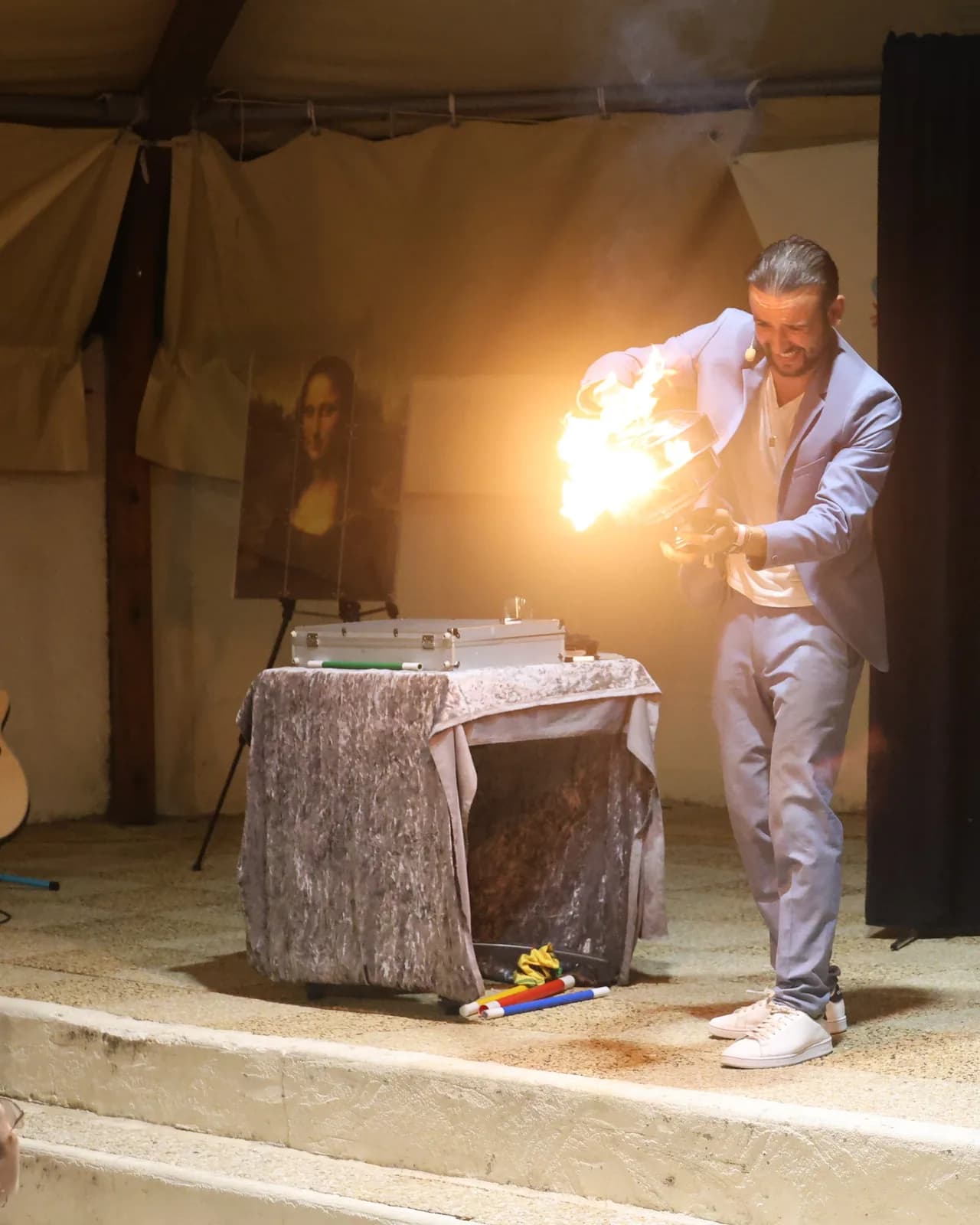 Tyson Dumas tenant une flamme lors d'un spectacle de magie sur scène