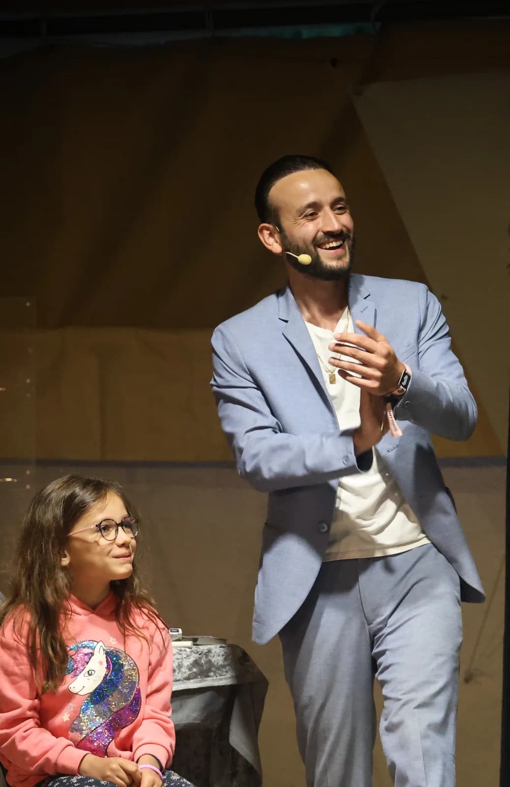 Tyson Dumas sur scène lors d'un spectacle de magie avec une jeune spectatrice