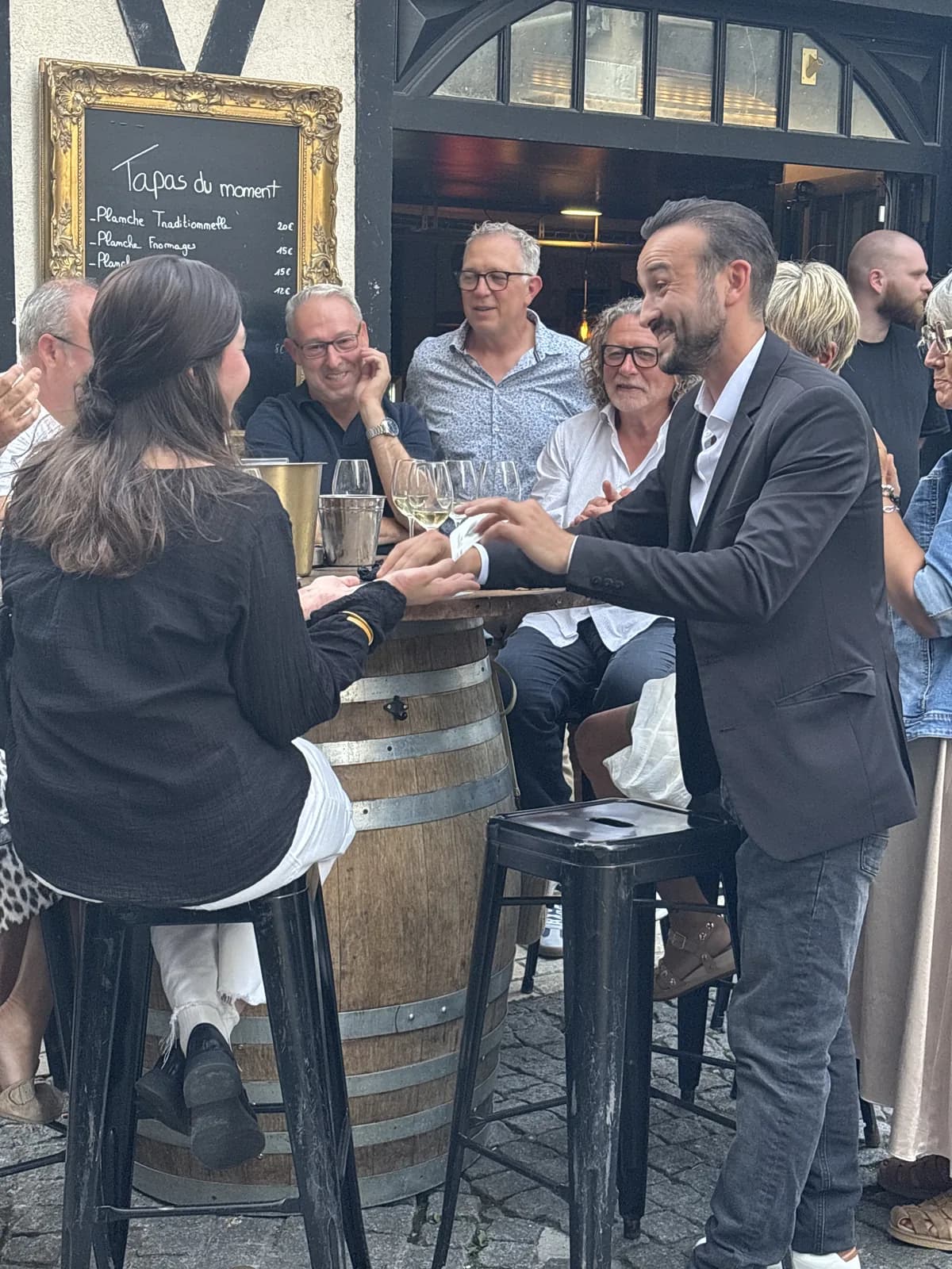 Tyson Dumas présentant un tour de cartes à une spectatrice lors d'une prestation magie de bar à Angoulême